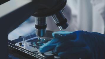 Young scientists conducting research investigations in a medical laboratory, a researcher in the foreground is using a microscope video