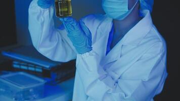 Young scientists conducting research investigations in a medical laboratory, a researcher in the foreground is using a microscope video