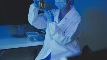 Young scientists conducting research investigations in a medical laboratory, a researcher in the foreground is using a microscope video