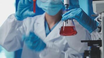 Young scientists conducting research investigations in a medical laboratory, a researcher in the foreground is using a microscope video