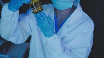 Young scientists conducting research investigations in a medical laboratory, a researcher in the foreground is using a microscope video