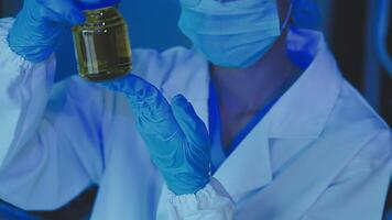 Young scientists conducting research investigations in a medical laboratory, a researcher in the foreground is using a microscope video