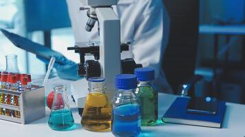 Young scientists conducting research investigations in a medical laboratory, a researcher in the foreground is using a microscope video