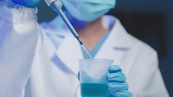 Young scientists conducting research investigations in a medical laboratory, a researcher in the foreground is using a microscope video