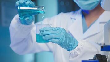 Young scientists conducting research investigations in a medical laboratory, a researcher in the foreground is using a microscope video