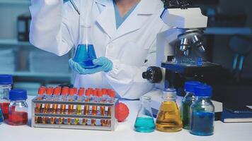 Young scientists conducting research investigations in a medical laboratory, a researcher in the foreground is using a microscope video