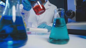 Young scientists conducting research investigations in a medical laboratory, a researcher in the foreground is using a microscope video