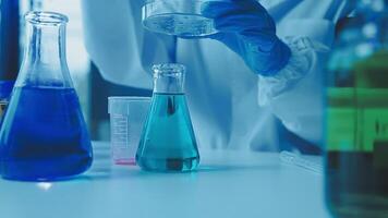 Young scientists conducting research investigations in a medical laboratory, a researcher in the foreground is using a microscope video