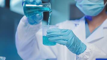 Young scientists conducting research investigations in a medical laboratory, a researcher in the foreground is using a microscope video