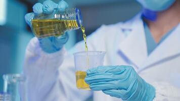 Young scientists conducting research investigations in a medical laboratory, a researcher in the foreground is using a microscope video