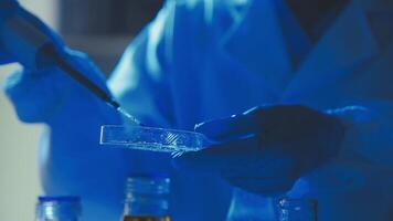 Young scientists conducting research investigations in a medical laboratory, a researcher in the foreground is using a microscope video