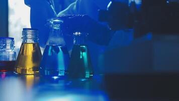 Young scientists conducting research investigations in a medical laboratory, a researcher in the foreground is using a microscope video