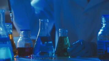 Young scientists conducting research investigations in a medical laboratory, a researcher in the foreground is using a microscope video