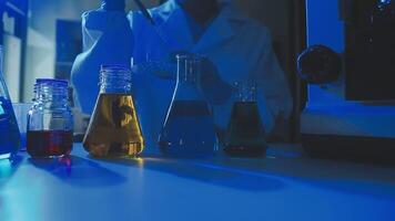 Young scientists conducting research investigations in a medical laboratory, a researcher in the foreground is using a microscope video