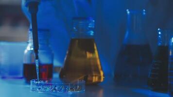 Young scientists conducting research investigations in a medical laboratory, a researcher in the foreground is using a microscope video