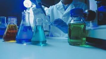 Young scientists conducting research investigations in a medical laboratory, a researcher in the foreground is using a microscope video