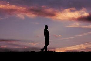 hombre silueta en el campo en el verano y puesta de sol antecedentes foto