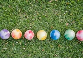 AI generated Spread in a row on the grass children's colorful toy balls. photo