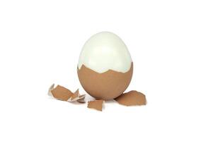 Egg, mostly peeled, against a white background photo