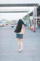 Beautiful Asian woman poses in fashion style, white shirt, jeans skirt. photo