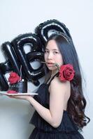 hermosa mujer vistiendo un negro vestir y chocolate pastel en el concepto de cumpleaños foto