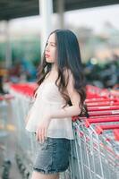 Beautiful Asian woman poses in fashion style, white shirt, jeans skirt. photo