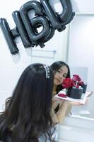 Beautiful woman wearing a black dress and chocolate cake in the concept of birthday photo