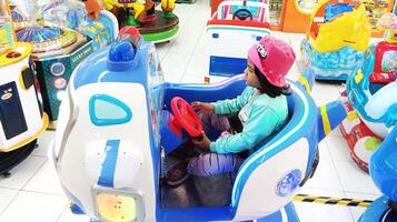 semarang, Indonesia - febrero, 2024 - un niña paseos un avión juego en el patio de recreo foto