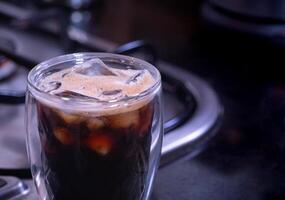 fresh espresso into a glass with ice cubes. Fresh ice coffee, espresso, with thick, soft crema foam to mix with water to make an Americano. Brew coffee from Arabica and Robusta beans. photo