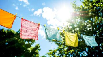 AI Generated  Brightly colored laundry hangs on a line in bright sunlight, against a backdrop of lush greenery, copy space. photo