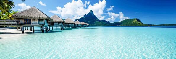 AI Generated Overwater bungalows with a mountain backdrop under a clear blue sky, perfect for travel themes. for travel brochures, holiday websites, and tropical destination marketing. photo