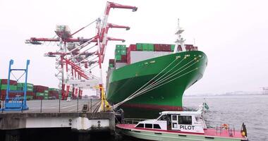 A large ship near the container wharf in Tokyo cloudy day wide shot video