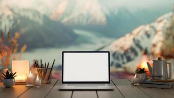 A laptop computer on a wooden table, with a blurred background of snow-covered alpine mountains. photo