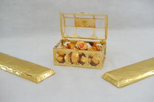 golden box with chocolate and gold chocolate bars on a white background. chinese new year photo