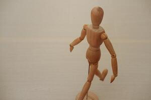Wooden mannequin standing on a wooden background. Selective focus. photo