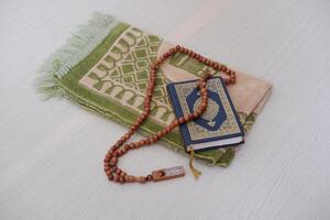 Holy Quran with rosary on a wooden table. Ramadan Kareem. photo