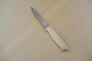 Kitchen knife on a wooden table. Kitchen utensils. photo