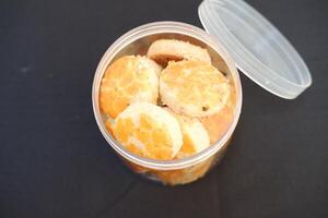 peanut cookies in a plastic box on a black tablecloth. photo