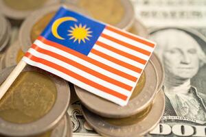 Stack of coins with Malaysia flag and US dollar banknotes. photo