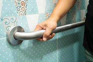 Asian elderly woman use toilet bathroom handle security, healthy strong medical concept. photo