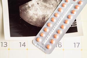 Pregnancy birth control pills with ultrasound scan of baby uterus, contraception health and medicine. photo