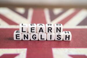Word Learn English on book with United Kingdom flag, learning English language courses concept. photo
