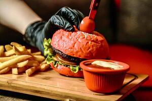 Juicy Hamburger and Golden Fries on Cutting Board photo