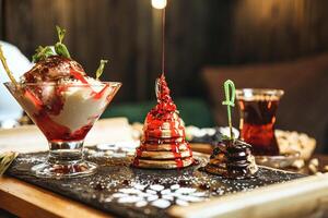 Wooden Table Adorned With Assorted Desserts and Refreshing Drinks photo