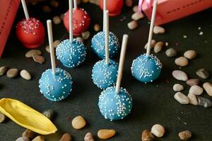 Table With Blue Cake Pops Covered in White Sprinkles photo