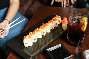 plato de Sushi con palillos y un bebida foto