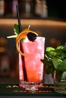 Tall Glass of Pink Drink Garnished With Blackberries photo