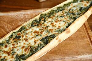 Spinach and Cheese Pizza on Cutting Board photo