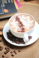 A Cappuccino on a Saucer Surrounded by Coffee Beans photo