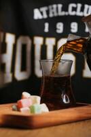Pitcher Pouring Tea Into Glass With Marshmallows photo